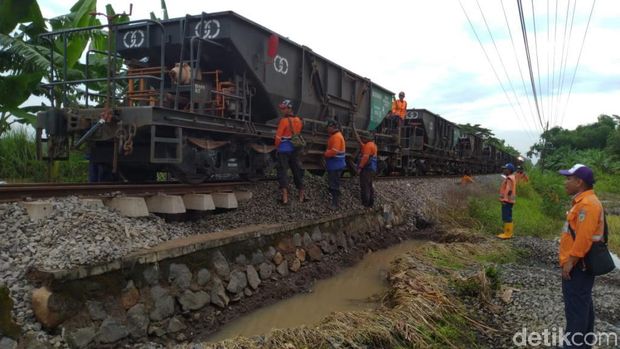 Petugas KA membawa batu kricak ke lokasi banjir/