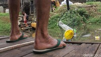 Uniknya, Saepudin tak hanya menarik perahu eretan untuk mengantarkan penumpangnya tetapi ia juga mengangkat botol plastik yang nampak hanyut di kali tersebut.