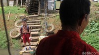 Bersama menantunya, Saepudin menarik perahu eretan di kali Banjir Kanal Barat, Jakarta.
