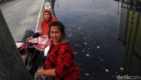Dua warga berbincang di tepi Kali Item.