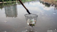 Saepudin bersama menantunya biasanya mengumpulkan botol plastik saat mengantarkan penumpangnya menyeberang. Menggunakan jaring, kedua pria tersebut menjaring botol-botol plastik yang hanyut di Kali Banjir Kanal Barat.