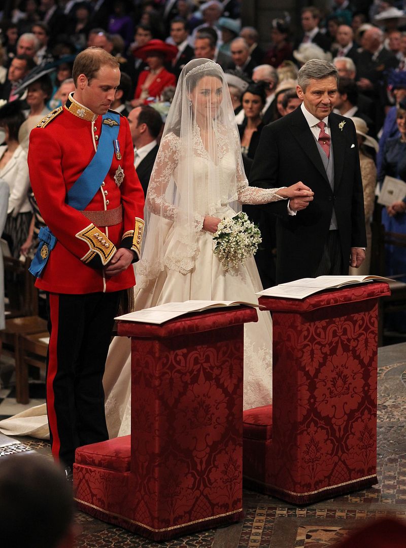 Kate Middleton LONDON, ENGLAND - APRIL 29: Prince William stands beside his bride Catherine Middleton as she holds the hand of her father Michael Middleton on April 29, 2011 in London, England. The marriage of Prince William, the second in line to the British throne, to Catherine Middleton is being held in London today. The marriage of the second in line to the British throne is to be led by the Archbishop of Canterbury and will be attended by 1900 guests, including foreign Royal family members and heads of state. Thousands of well-wishers from around the world have also flocked to London to witness the spectacle and pageantry of the Royal Wedding. (Photo by Dominic Lipinski - WPA Pool/Getty Images)