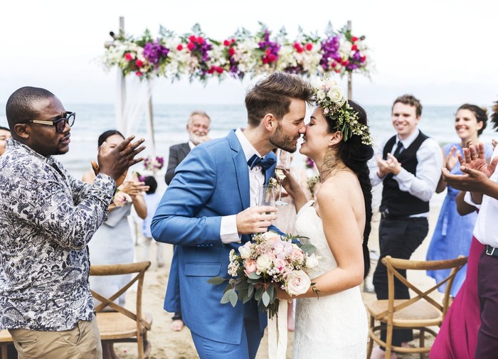 ilustrasi pernikahan Young couple kissing at wedding reception