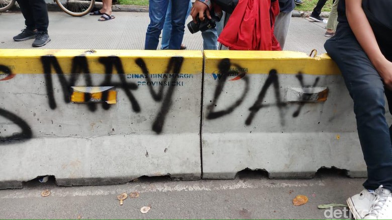 Di Tengah Aksi Buruh, Separator Busway di Patung Kuda Dicoret-coret Di Tengah Aksi Buruh, Separator Busway di Patung Kuda Dicoret-coret