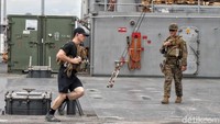 Seorang prajurit tengah berlari di atas USS Blue Ridge.
