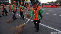 Petugas menyapu jalan raya yang sebelumnya dijadikan lokasi aksi.
