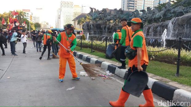 Pasukan oranye bersih-bersih usai Hari Buruh di Patung Kuda