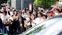 Warga menyambut senang saat mobil kaisar melintas. REUTERS/Kim Kyung-Hoon.