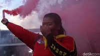 Seorang buruh wanita menyalakan flare.