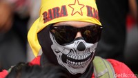 Aksi salah seorang buruh, tampil dengan buff dan ikat kepala.