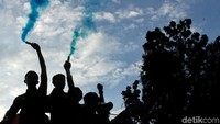 Sejumlah peserta aksi terlihat membakar flare.