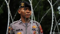 Polisi berjaga dibalik kawat berduri.