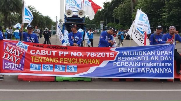 Massa buruh juga membentangkan spanduk bertuliskan 'cabut PP No 78/2015'.