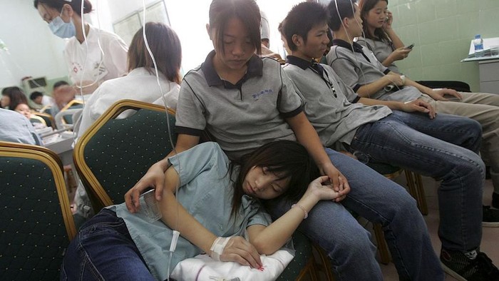 SHENZHEN, CHINA - SEPTEMBER 20: (CHINA OUT) Workers stricken by food poisoning receive treatment at the Peoples Hospital of Longhua on September 20, 2006 in Shenzhen of Guangdong Province, China. In stable condition now about one hundred and eighty workers from Shenzhen Foxconn Group were hospitalized after contracting food poisoning at Foxconn?s factory. Local sanitation and epidemic prevention and disease control departments have taken sample foods for testing. (Photo by China Photos/Getty Images)