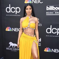 Cardi B memamerkan perut ratanya dengan gaun seksi berwarna kuning dari Moschino. Gaun yang dirancang khusus oleh Jeremy Scott untuk sang rapper dihiasi detail batu permata warna-warni yang menyempurnakan penampilannya. Foto: Getty Images