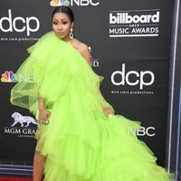Yung Miami mencuri atensi dengan gaun tulle berwarna hijau neon. Namun siluet gaun yang bervolume ini justru membuat ia terkesan tenggelam dalam tumpukan kain. Foto: Dok. Getty Images