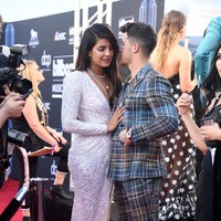 Pada ajang Billboard Music Awards 2019, Nick Jonas tampil bersama dua saudaranya Joe Jonas dan Kevin Jonas membawakan single terbaru dari band mereka Jonas Brothers, Sucker. Dan saat tampil itu mendadak Nick memberikan kejutan manis pada Priyanka Chopra. Penyanyi tampan itu mencuri-curi kesempatan mencium aktris India tersebut. Sambil berjalan ke atas panggung dan bermain gitar, Nick mendaratkan ciuman pada Priyanka. Foto: Dok. Getty Images, Instagram