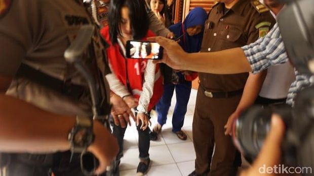 Vanessa Angel saat membetulkan sepatu dengan tangannya yang terborgol