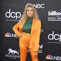 Tori Kelly tampil dengan setelan bernuansa oranye dan ia padukan bersama turtleneck hijau kontras yang senada seperti sepatunya. Sayang paduan ini tak terlihat bagus tampil bersama, dan justru tampak seperti kostum dari serial tahun 70-an. Foto: Dok. Getty Images