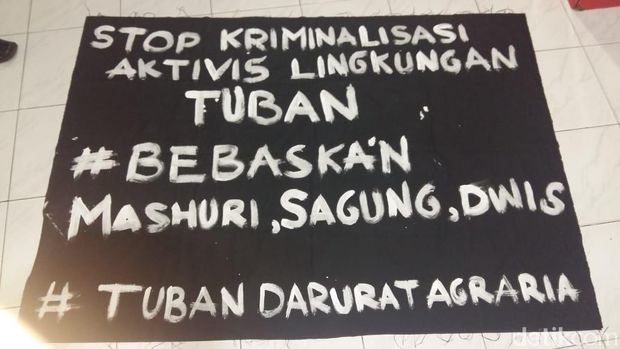 Poster yang dibawa massa berbaju hitam-hitam/