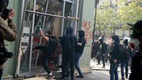 Gerombolan bermasker itu melempari polisi dengan botol dan benda-benda lainnya. Tayangan televisi setempat menunjukkan kaca jendela sebuah van pecah akibat aksi ini.