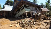 Seorang warga berdiri di depan rumahnya yang ambruk diterjang banjir bandang di Desa Genting, Kecamatan, Bang Haji, Bengkulu Tengah, Kamis (2/5/2019).