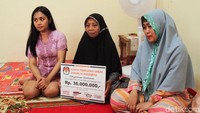Istri almarhum Umar, Ibu Tuti memegang papan simbolis santunan dari KPU di kediamannya di Jl. Pahlaean II, Sukabumi Selatan, Kebon Jeruk, Jakarta Barat, Jumat (3/5/2019).