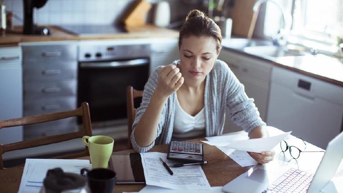Close up of a young woman doing her bills in the kitchen