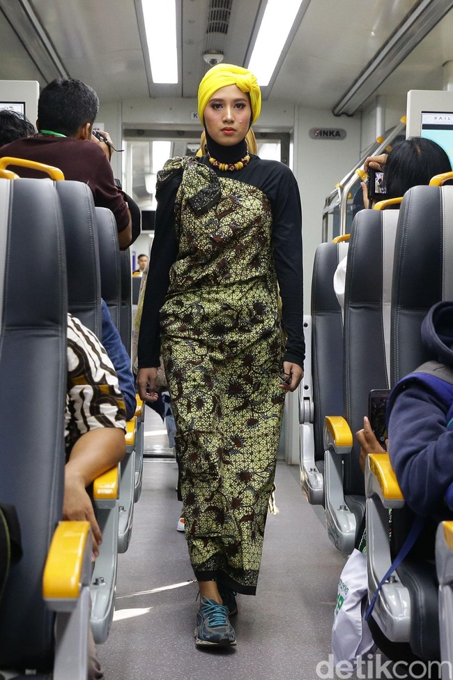 Model berjalan di gerbong kereta melewati para penumpang kereta bandara yang hendak menuju Stasiun Bandara Soekarno Hatta. Perjalanan kereta bandara ini sendiri dimulai dari Stasiun Sudirman. Foto: Grandyos Zafna/detikcom