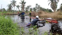 Dengan drum-drum kosong, tiang listrik dibawa melalui sungai. Pool/PLN.