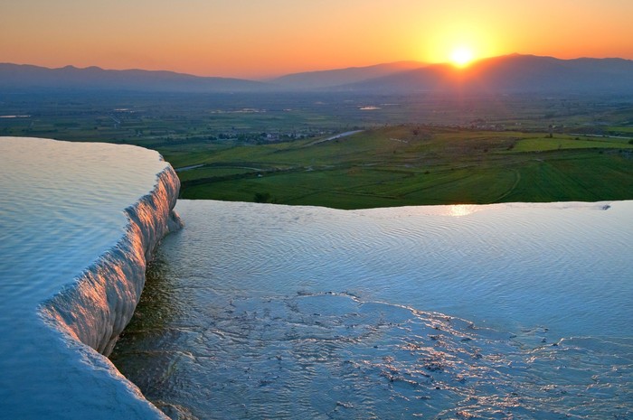 kolam pamukkale di turki Illuminated Pamukkale terraces against sunset sky background. Denizli city lights in the middle of composition.