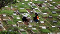 Seorang anak ikut orang tuanya berziarah.