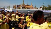 Warga mengenakan pakaian serba kuning nampak antusias menyambut kedatangan Raja Maha Vajiralongkorn. Penobatan Raja baru Thailand ini merupakan penobatan raja yang pertama sejak tahun 1950. Navesh Chitrakar/Reuters.