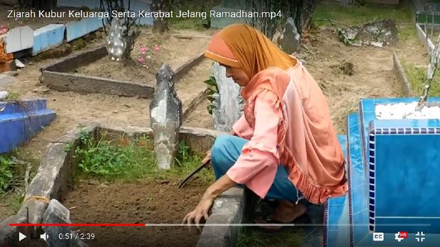 Ani terlihat membersihkan makam anaknya.