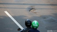 Jalan berlubang itu terlihat di sejumlah titik.