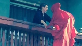 Wanita tersebut seperti mengangkat sosok berjubah merah. Foto: facebook.com/Inspire2daycom/