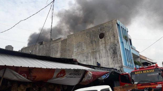 Asap hitam membumbung dari gudang yang terbakar itu.