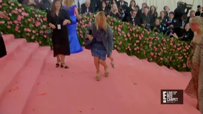 Berdandan sebagai Cinderella, Zendaya harus meninggalkan sepatunya. Asisten wanita ini pun dengan setiap memastikan agar sepatu kaca tersebut tidak menggangu pemakai kostum heboh lain yang akan lewat. Foto: dok E!