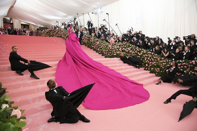 Gaun berwarna pink neon tersebut hadir dengan train atau ekor sepanjang hampir delapan meter di MET Gala 2019. Gaga lalu menyempurnakan gayanya dengan headpiece berhiaskan pita bervolume dan riasan wajah nan dramatis. (Foto: Getty Images)