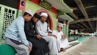 Sejumlah warga juga tampak berdiskusi di depan Masjid Babah Alun, Jakarta sambil menghabiskan waktu dengan kegiatan yang bermanfaat.