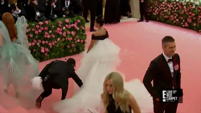 Lana Condor terlihat seperti princess dalam foto-foto para fotografer. Lana pun harus berterima kasih dengan sang asisten yang tak lelah memperbaiki tulle-nya sehingga selalu kelihatan cantik. Foto: dok E!