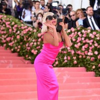 Penampilan Gaga lalu berubah lagi di MET Gala 2019. Kali ini, ia memakai column dress berwarna pink neon yang dipadu dengan oversized sunglasses.  (Foto: Getty Images)