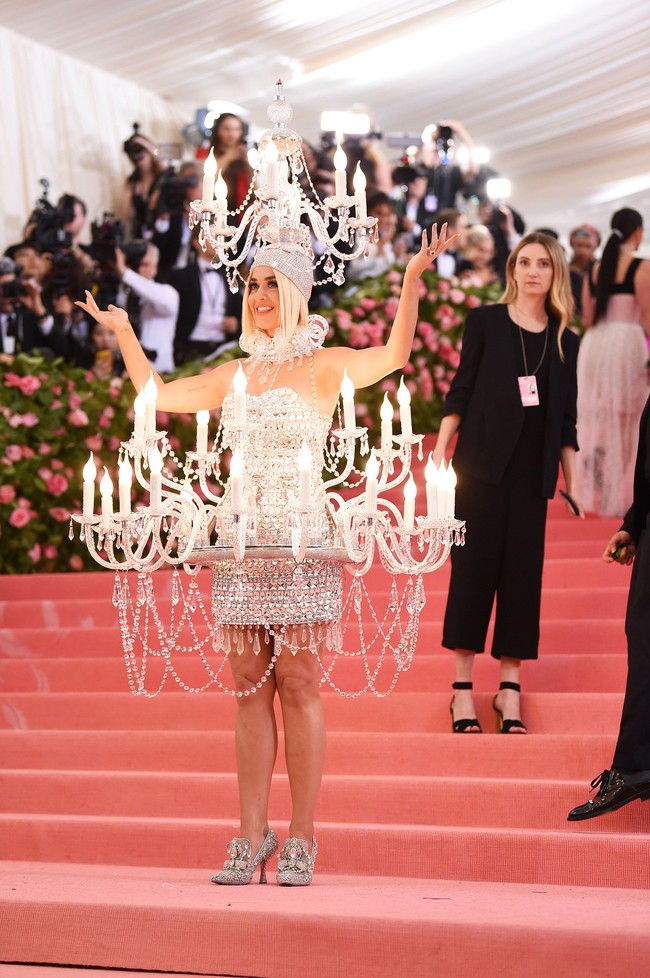 Selebriti yang juga tampil heboh di Met Gala 2019 adalah Katy Perry. Membawa dua buah chandelier, tentu penyanyi tersebut rentan celaka. Karena seorang asisten wanita mengawasi setiap langkah Katy agar bisa berjalan di red carpet dengan selamat. Foto: Getty Images