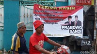 Pengendara sepeda motor melintas di depan spanduk Prabowo dan Sandiaga, Selasa (7/5/2019).