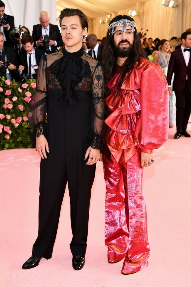 Harry Styles hadir bersama desainer Alessandro Michele dari Gucci yang karyanya dia pakai ke MET Gala 2019. Sang desainer sendiri tampil memakai busana pink dengan detail empat pita besar. Foto: Jamie McCarthy/Getty Images