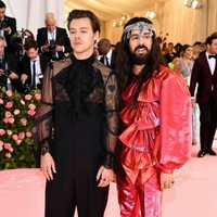 Harry Styles hadir bersama desainer Alessandro Michele dari Gucci yang karyanya dia pakai ke MET Gala 2019. Sang desainer sendiri tampil memakai busana pink dengan detail empat pita besar. Foto: Jamie McCarthy/Getty Images