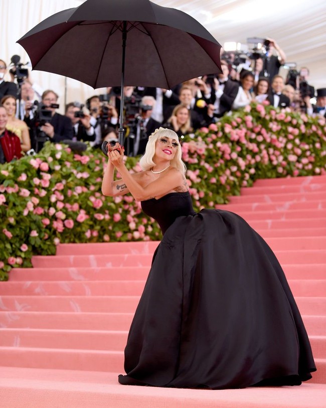 Gaun tersebut ternyata hanyalah sebagai luaran. Di dalamnya terdapat gaun hitam dengan rok asimetris berstruktur. Dalam balutan gaun tersebut, pemenang Oscar ini berpose sambil memegang payung senada di hadapan para fotografer MET Gala 2019. (Foto: Getty Images)