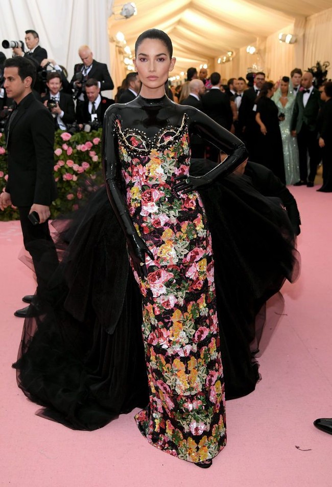 Lily Aldridge memakai gaun floral rancangan desainer Richard Quinn. Gaun tersebut punya keunikan di area dada dan lengan. Quinn mengombinasikan aura feminin dan edgy dengan penggunaan material lateks hitam super ketat. Penampilannya pun makin dramatis dengan detail train di bagian belakang. Foto: Neilson Barnard/Getty Images