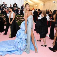 Candice Swanepoel tak kalah seksi berbalut gaun high-slit biru rancangan Atelier Prabal Gurung. Keseluruhan gaun bertaburan payet dan terkesan dramatis berkat train panjang bervolume. Tatanan rambut kuncir tinggi dengan detail sulur membuat penampilannya seperti jin seksi. Foto: Dimitrios Kambouris/Getty Images