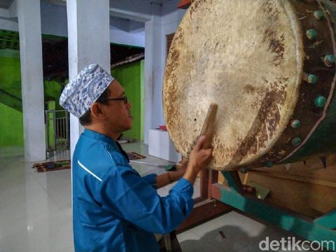 Seorang santri menabuh bedug untuk mengiringi selawatan
